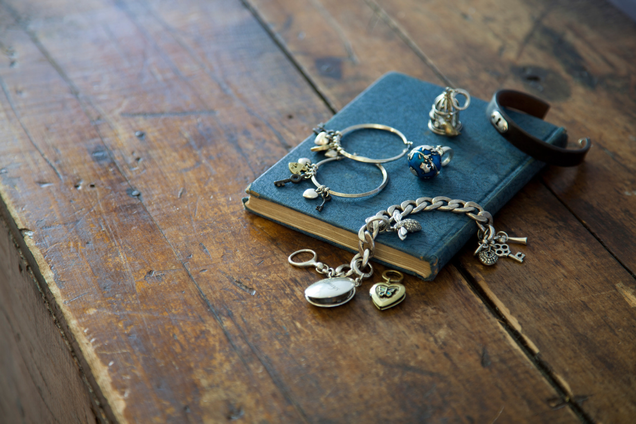 antique pieces of jewelry sitting on a blue book